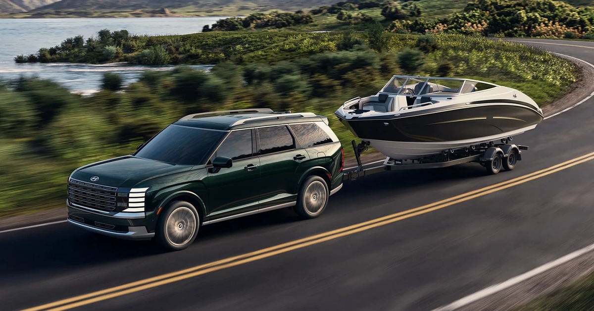 Hyundai Palisade towing a boat on a scenic road